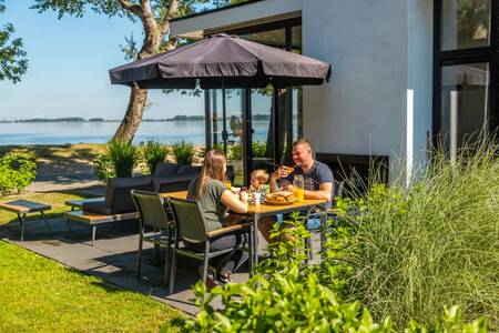 Family eating in the garden of a holiday home at the Europarcs Bad Hoophuizen holiday park