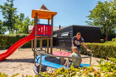 Father and child play in the playground at the Europarcs Bad Hoophuizen holiday park