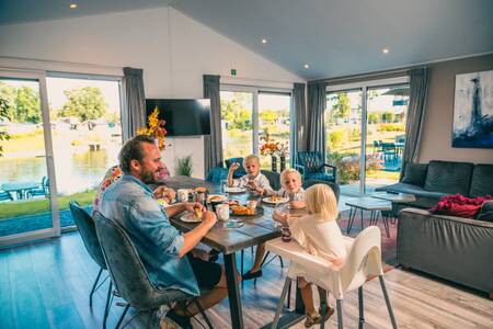Family eating in a holiday home at holiday park Europarcs EuroParcs Zilverstrand