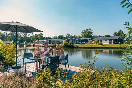 Family eating in the garden of a holiday home at the Europarcs EuroParcs Zilverstrand holiday park