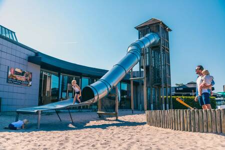 Child slides down the slide in a playground at the Europarcs EuroParcs Zilverstrand holiday park