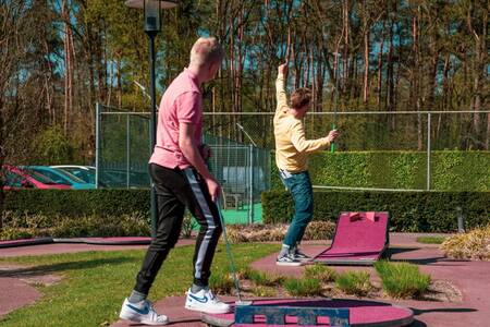 Two men play mini golf on the mini golf course of holiday park Europarcs de Achterhoek