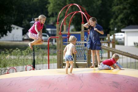 Children jump on the air trampoline in a playground at the Familiehuis Nunspeet holiday park