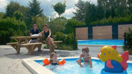 Children in the paddling pool outside at Bungalow Park Het Verscholen Dorp