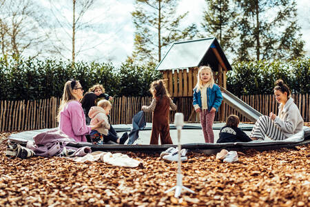 2 women with children on the trampoline in the playground at the Het Wylde Pad holiday park