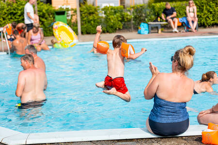 People swimming in the outdoor pool of holiday park Leukermeer