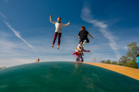 Children jump on the air trampoline in a playground at holiday park Wilsumer Berge