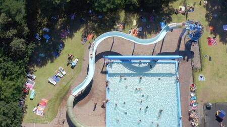 Aerial view of people in the outdoor pool and large slide at the Witterzomer holiday park