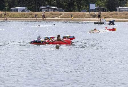 Children play with inflatable boats on the lake at the Witterzomer holiday park
