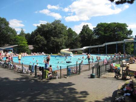 People in the outdoor pool with a large slide at the Witterzomer holiday park