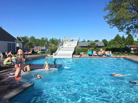 People swimming in the outdoor pool of holiday park 't Rheezerwold