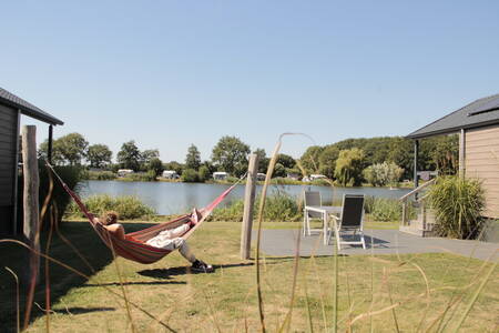 Man in a hammock in the garden of a lodge on the water on Krieghuusbelten