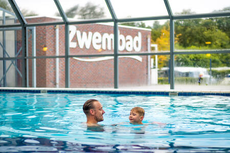 Father with child swimming in the indoor pool of Krieghuusbelten