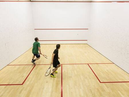 2 men playing squash on the squash court of Landal Alpen Resort Vierwaldstättersee