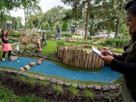 Playing golf on the mini golf course at the Landal Amerongse Berg holiday park