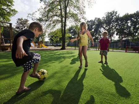 Children play on a playing field at a playground at the Landal Amerongse Berg holiday park
