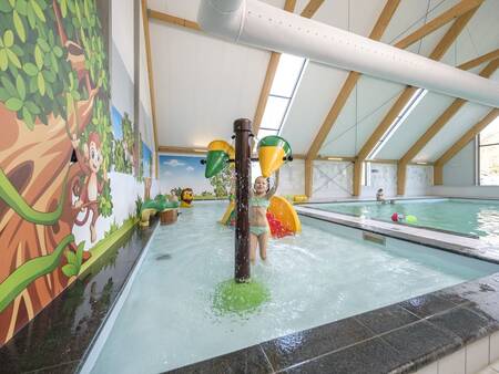 Child plays in the paddling pool of the swimming pool of the Landal Amerongse Berg holiday park