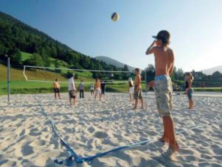 Children play volleyball on a volleyball court at the Landal Bad Kleinkirchheim holiday park