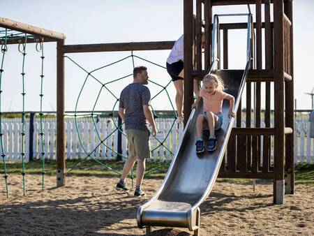 Children play in the playground at Landal Strandappartementen Fyrklit