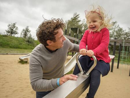 Girl on a seesaw in a playground at holiday park Landal Beach Park Ebeltoft