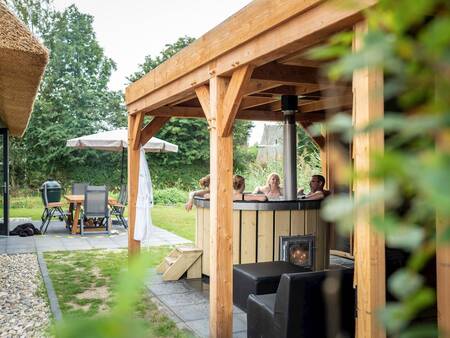 Covered veranda with wood-fired hot tub at a villa at Landal Berger Duinen holiday park