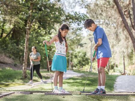 Children play golf on the mini golf course at holiday park Landal Coldenhove