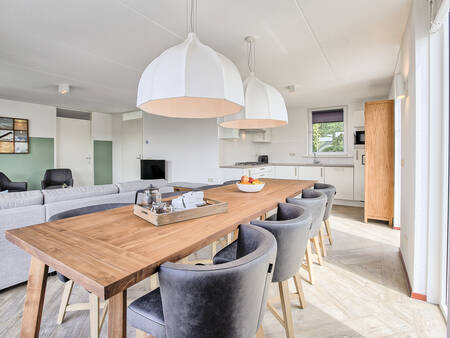 Table and kitchen of a holiday home at Landal De Bloemert holiday park