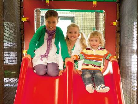 Children on a slide in the indoor playground of holiday park Landal De Vers