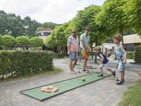 A family plays a game of mini golf at the Landal De Vers holiday park