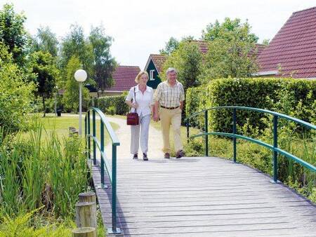 Couple walks over a bridge at Landal Duc de Brabant holiday park