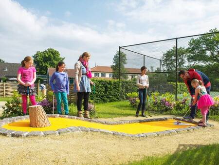 Family plays golf on the mini golf course of holiday park Landal Duc de Brabant