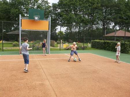 Children play football on the multifunctional sports field at the Landal Duc de Brabant holiday park