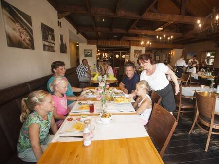 Family at the table at restaurant Auberge De Hilver at Landal Duc de Brabant holiday park
