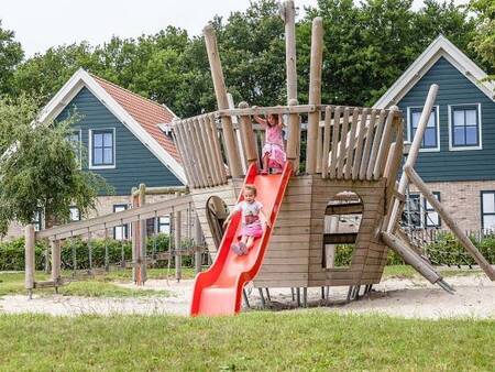 Children play in a playground at holiday park Landal Duinpark 't Hof van Haamstede