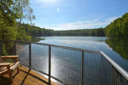 Balcony of a holiday home with a view over the water at Landal Forest Resort Your Nature