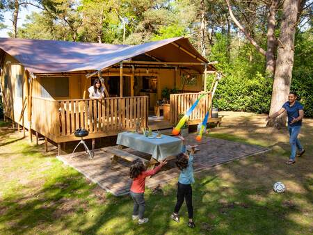 Family plays at their safari tent at Landal Gooise Heide holiday park