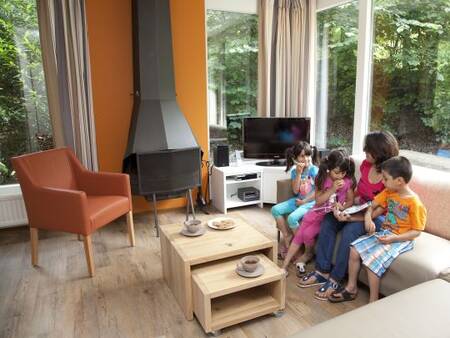 Family in the living room of a holiday home at Landal Heihaas holiday park