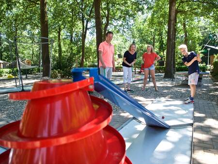 Family plays golf on the mini golf course at Landal Heihaas holiday park