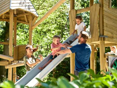 Family plays in a wooden playground at Holiday Park Landal Heihaas