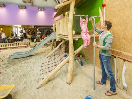 Father and child play in the indoor playground of holiday park Landal Het Land van Bartje