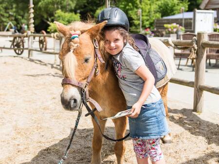 Girl with a pony on the pony ranch of holiday park Landal Het Land van Bartje