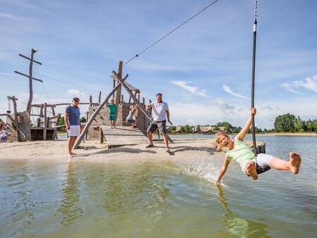 Children play in the playground at the recreational lake at Landal Hof van Saksen