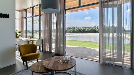 Living room with large patio doors to the garden at Landal Holiday Park Sallandse Heuvelrug