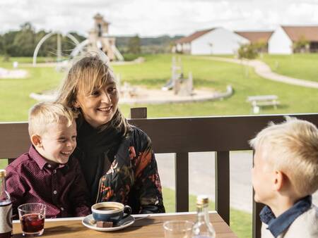 Family enjoys a drink on the terrace of the Brasserie at Landal Vakantiepark Søhøjlandet