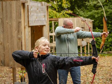 Father and daughter are archery at Landal Holiday Park Søhøjlandet