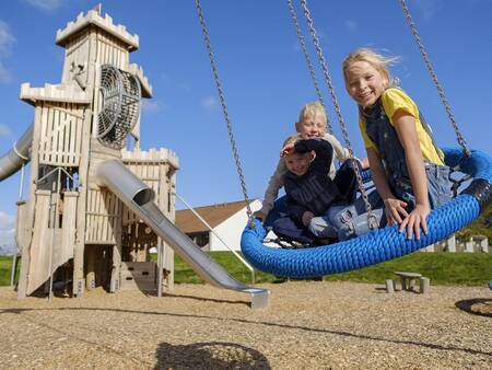 Children on the swing in the playground at Landal Vakantiepark Søhøjlandet