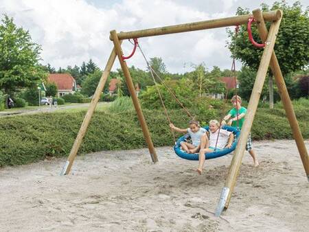 Children on a swing of a playground at the Landal Hunerwold State holiday park