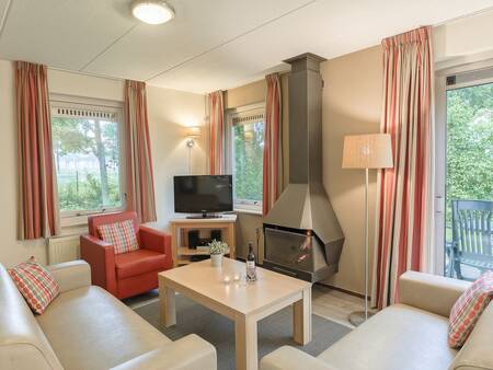 Living room with fireplace of a holiday home at the Landal Landgoed Aerwinkel holiday park