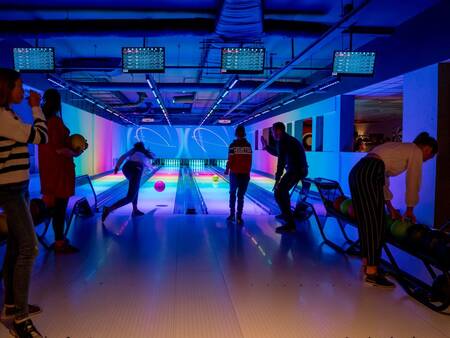 People bowling at the glow in the dark bowling alley of Landal Landgoed 't Loo
