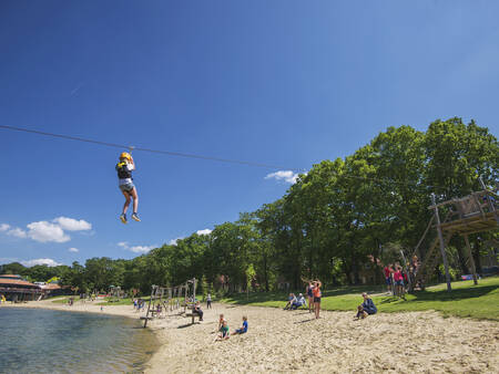 Boy on the zip line across the recreational lake at the Landal Landgoed 't Loo holiday park